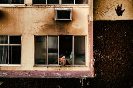 A woman at a window of her apartment in Cruzada Sao Sebastiao, in Leblon