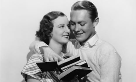 photo of two people embracing while holding some books