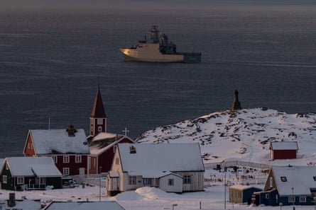HDMS Knud Rasmussen in sea with snow, spire and houses in foreground