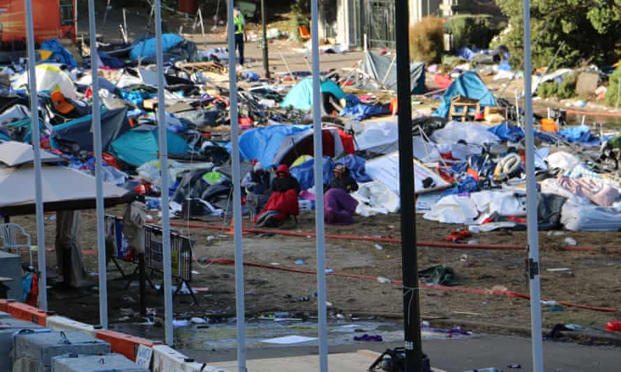 Protesters sit in the wreckage of the occupation after police cleared it.