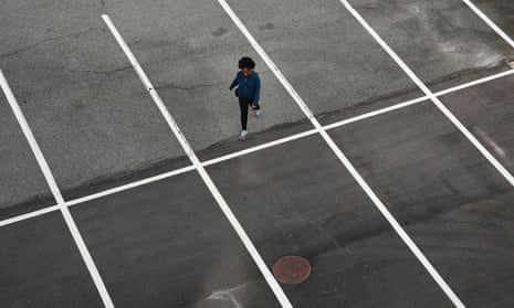 A woman walks through an empty mall parking lot in Atlanta, Georgia, days before the phased reopening of businesses and restaurants.