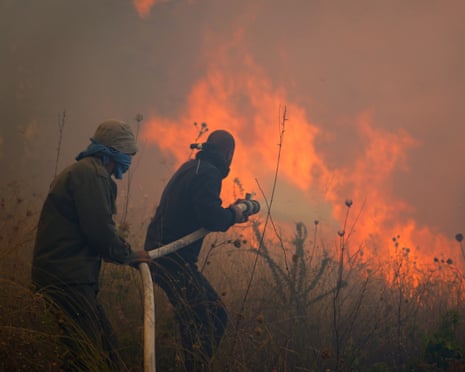 Smoke fills the air as firefighters battle a forest fire the Cypriot village of Omodos, in the Limassol province.