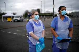 NHS nurses speak to the media as they wait for the next patient at a drive through Coronavirus testing site in Wolverhampton, England, last week