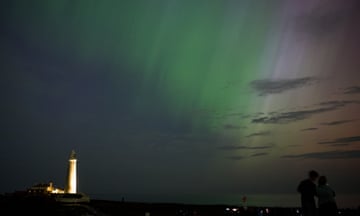 People by St Mary's lighthouse in Whitley Bay look at the aurora borealis
