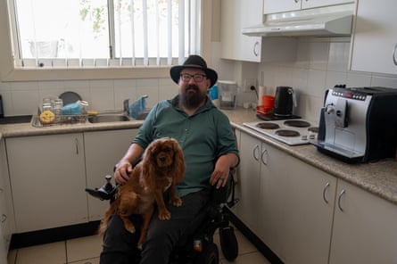 Disability advocate Jarrod Sandell-Hay in his kitchen with his dog
