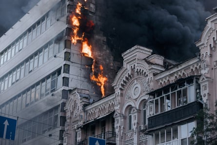 Flames and smoke billow from a high-rise building