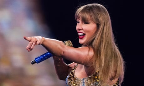 Taylor Swift sings while pointing at the audience