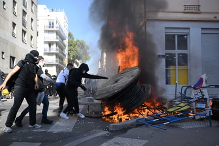 Protesters beside a fire burning in the street