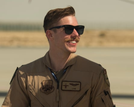 Jacob Wulfson smiling in sunglasses and a tan flight suit outdoors