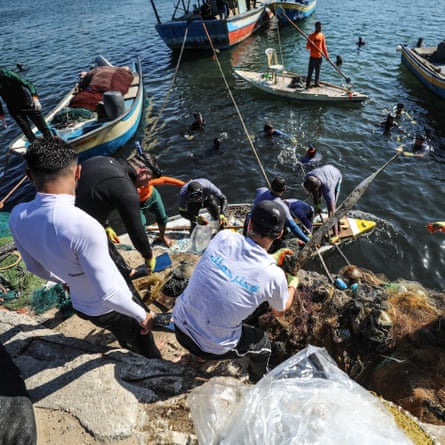 Volunteers clean up Port of Gaza from waste materials in Gaza City.