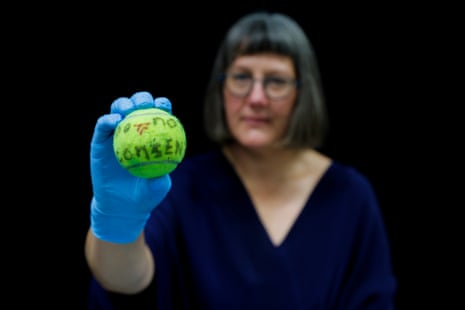 Curator Claire Regnault holding a tennis ball thrown at journalists during a protest
