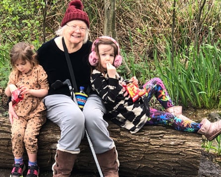 Anita Pollack with her granddaughters, sitting on a fallen tree log