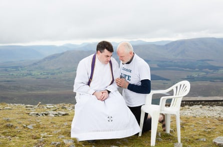 An anti-abortion campaigner recites the Eucharist with a priest at the summit of Croagh Patrick, a holy mountain in County Mayo, on 26 August 2017.