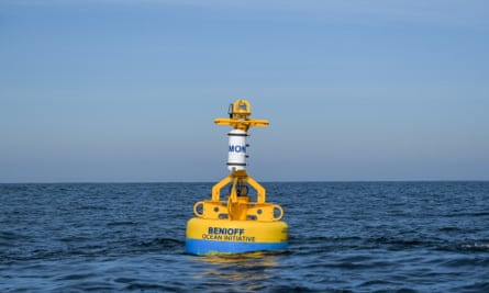 Une grosse bouée jaune flotte à la surface de l'océan.