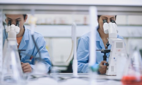 Scientists working in a laboratory with microscopes.