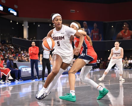 Angel Reese dribbles during a game.