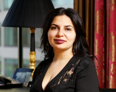 Ruja Ignatova in black dress in front of red and gold curtains