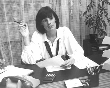 Black-and-white photograph of Marland at a desk featuring a rotary phone, calculator and in-tray