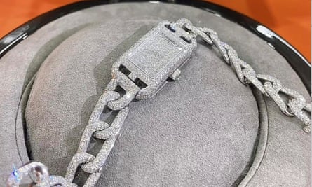 a sparkling, jewel-encrusted watch with a chain-design bracelet-style strap