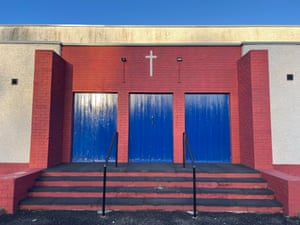 A rectangular church with details of the cross, three doors and a short flight of steps