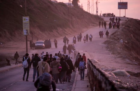 Los palestinos caminan por la carretera costera de Al-Rashid después de cruzar del norte al sur de Gaza.
