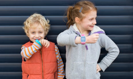 Two children wear the Gator Watch device