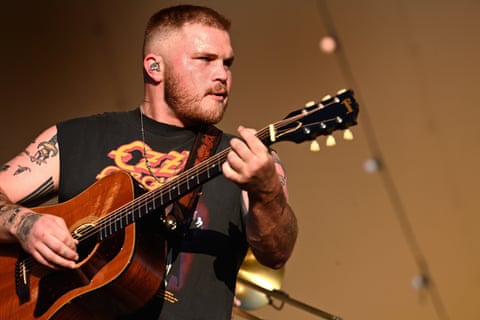 A man performs guitar on stage