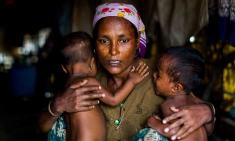 A mother – in a camp for Rohingya in Sittwe – Myanmar, holds onto her twins, both of whom suffer from malnutrition. 