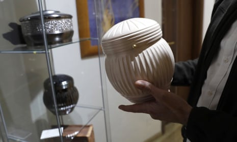 A man chooses an urn at a funeral parlour in Rome. 