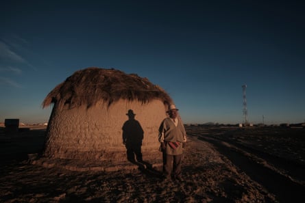A man standing in front of a small round house.