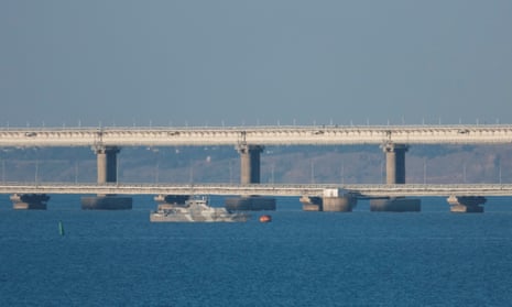 An armed ship sails next to the Crimean bridge connecting the Russian mainland with the Crimean peninsula across the Kerch Strait.