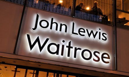 Illuminated combined John Lewis and Waitrose logos at the entrance to a store