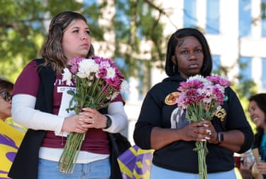 two women hold flowers