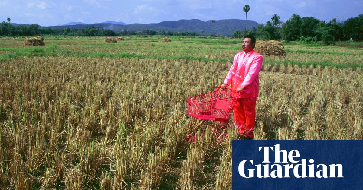 Pink Man pushing his pink trolley through a field in Thailand: Manit Sriwanichpoom's best photograph
