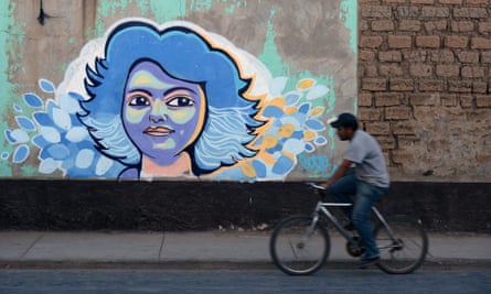 A man cycles past graffiti of Berta Cáceres in La Esperanza