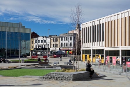 Glass Works Square in Barnsley, with modern buildings and a person seated on a stone bench