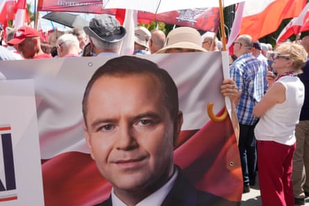 a demonstrator holds a flag bearing a man's face