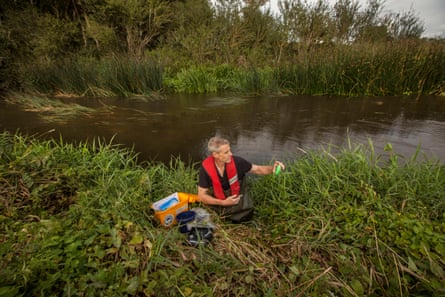 Russ Hatchet, a member of the Swallowfield Angling Club, wades out of the water with an analysis kit.