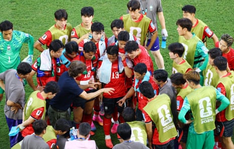 South Korea coach Hong Myung-bo gives instructions to his players during a hydration break