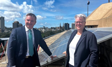 Federal energy minister Chris Bowen with NSW energy minister Penny Sharpe in front of solar panels on a city roof