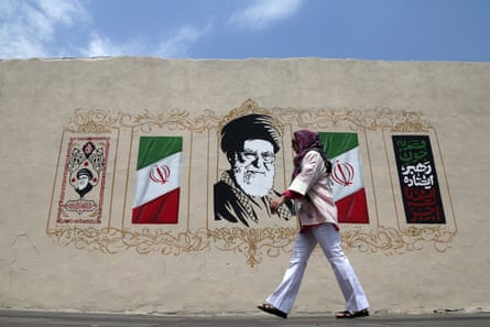 A woman walks in front of a mural
