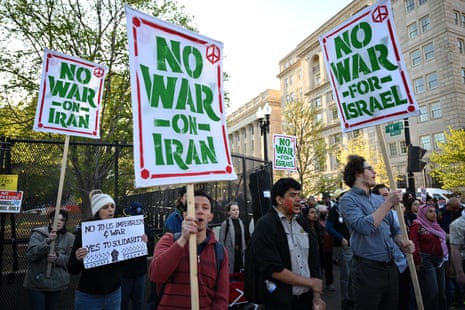 Demonstrators carry signs and chant slogans during a protest against US military action in Iran near the White House in Washington, DC, on April 7, 2026.