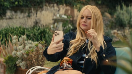 A woman holds her phone while eating Flamin’ Hot Cheetos