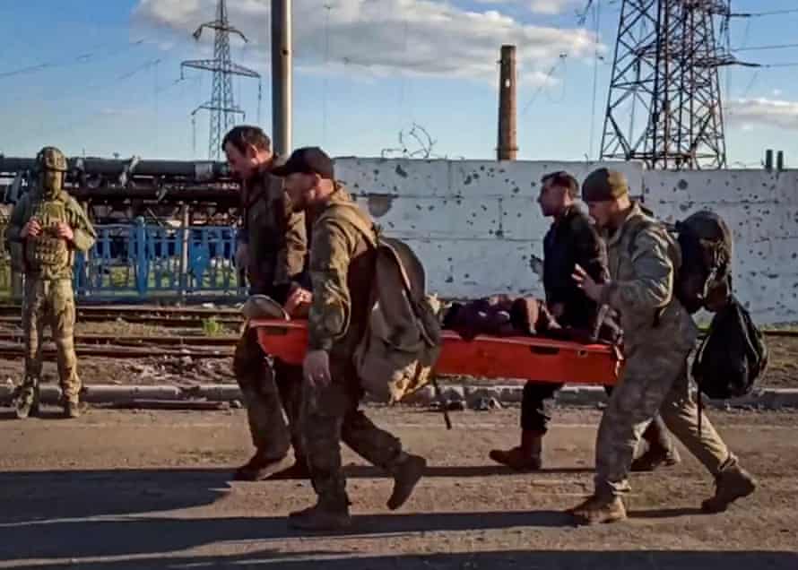 A handout still image taken from a handout video made available by the Russian Defence Ministry’s press service shows Ukrainian servicemen carry a wounded comrade as they are being evacuated from the besieged Azovstal steel plant in Mariupol, Ukraine, 17 May