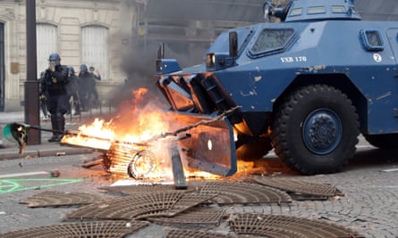 A Gendarmerie armored vehicles (VBRG) drives past fire near the Champs Elysees avenue in Paris on December 8, 2018