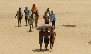 Villagers cover up in wet clothes as they walk back home after cooling off in the Daya river in Bhubaneswar, east India.