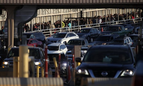People wait in line to enter the US at the Paso del Norte port of entry on 31 March in El Paso, Texas. 
