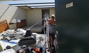 Jeannie Holcombe retrieves crutches for someone in need from a damaged room at the American Quality Lodge.