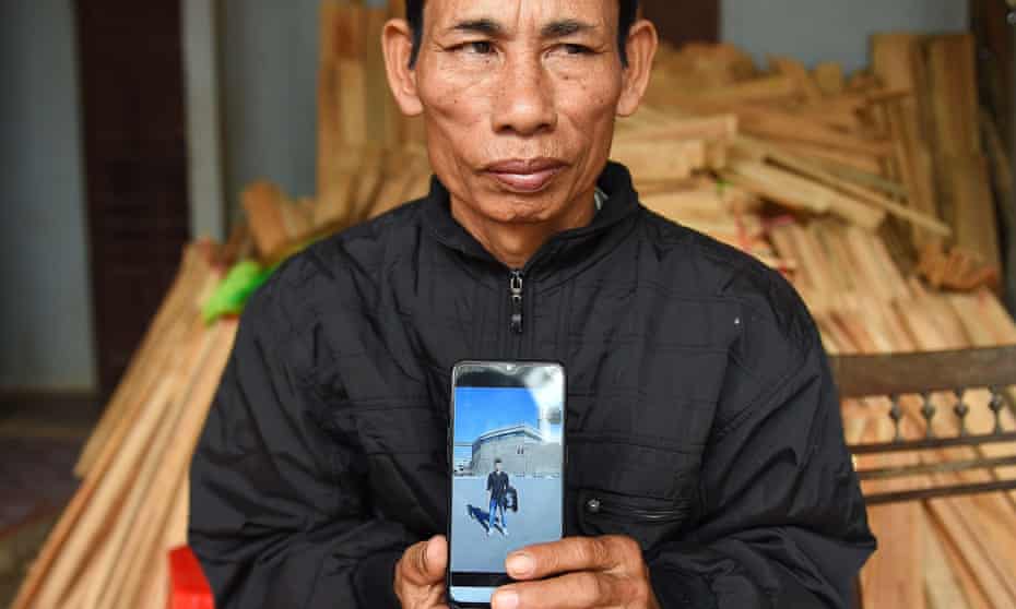 Nguyen Dinh Gia, father of 20-year-old Nguyen Dinh Luong, who is feared to be among the 39 people found dead, poses with his son’s photograph at their house in Vietnam’s Ha Tinh province.
