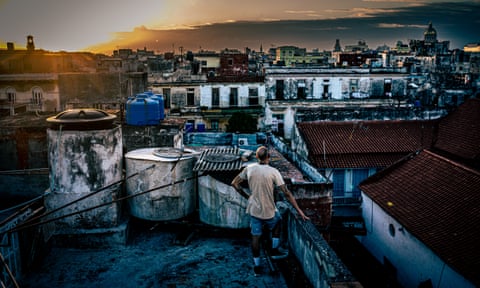 Rafael, 51, watches the sunset from the top of a building in San Isidro neighbourhood